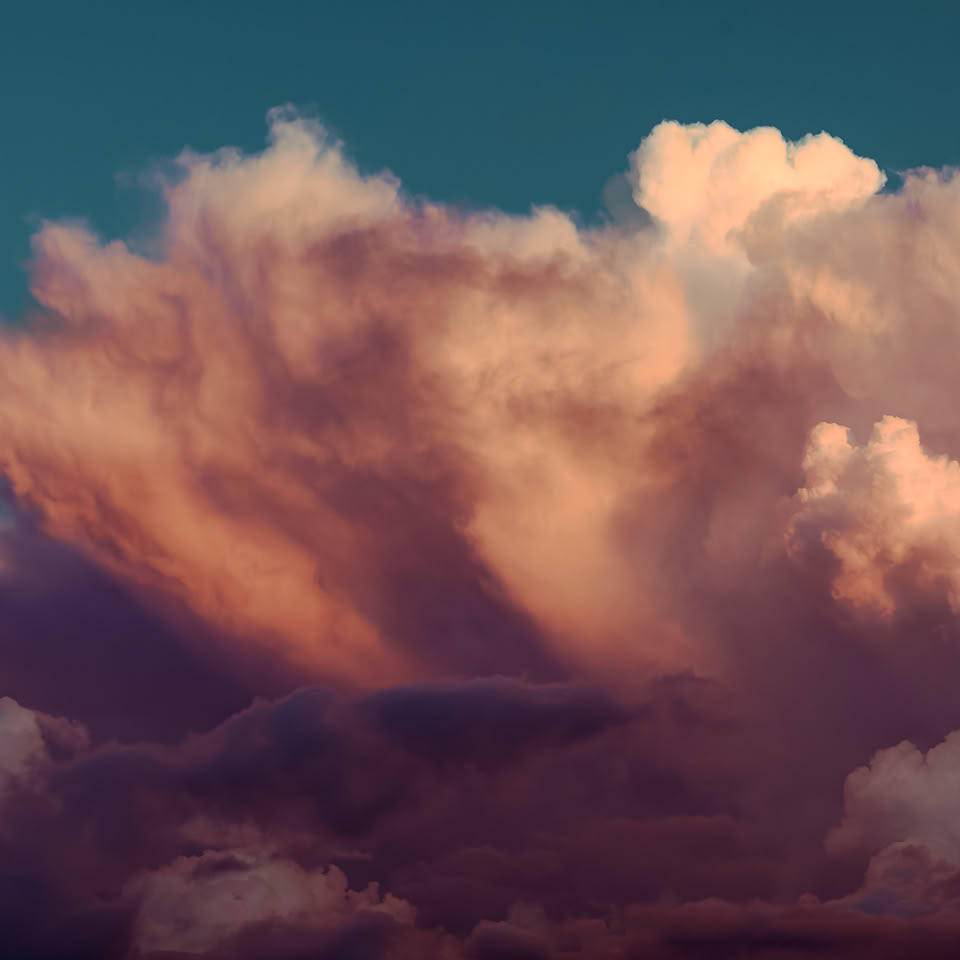 Nuages roses et orange dans un ciel bleu.