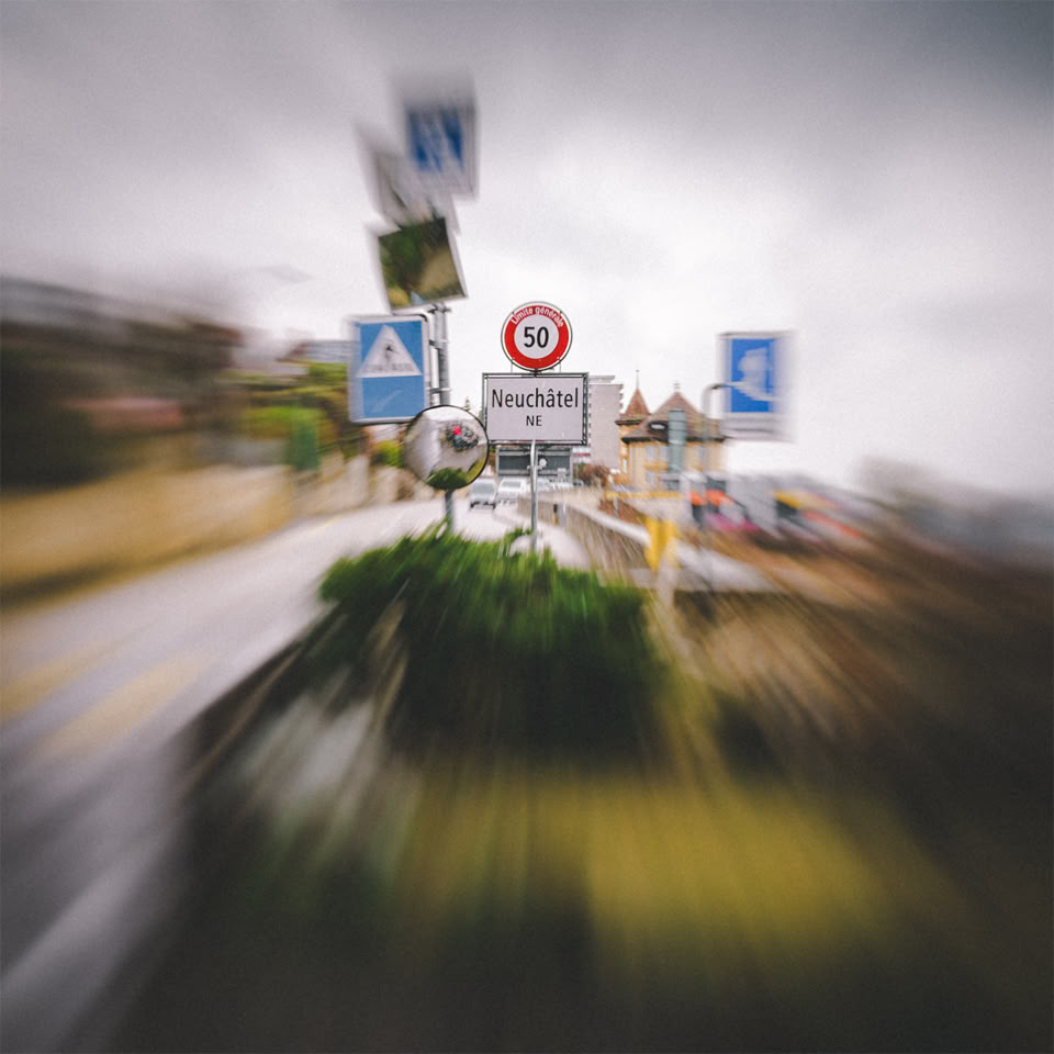 Panneaux de signalisation routière flous avec un effet de zoom, indiquant une limite de vitesse de 30 km/h et un passage piéton.